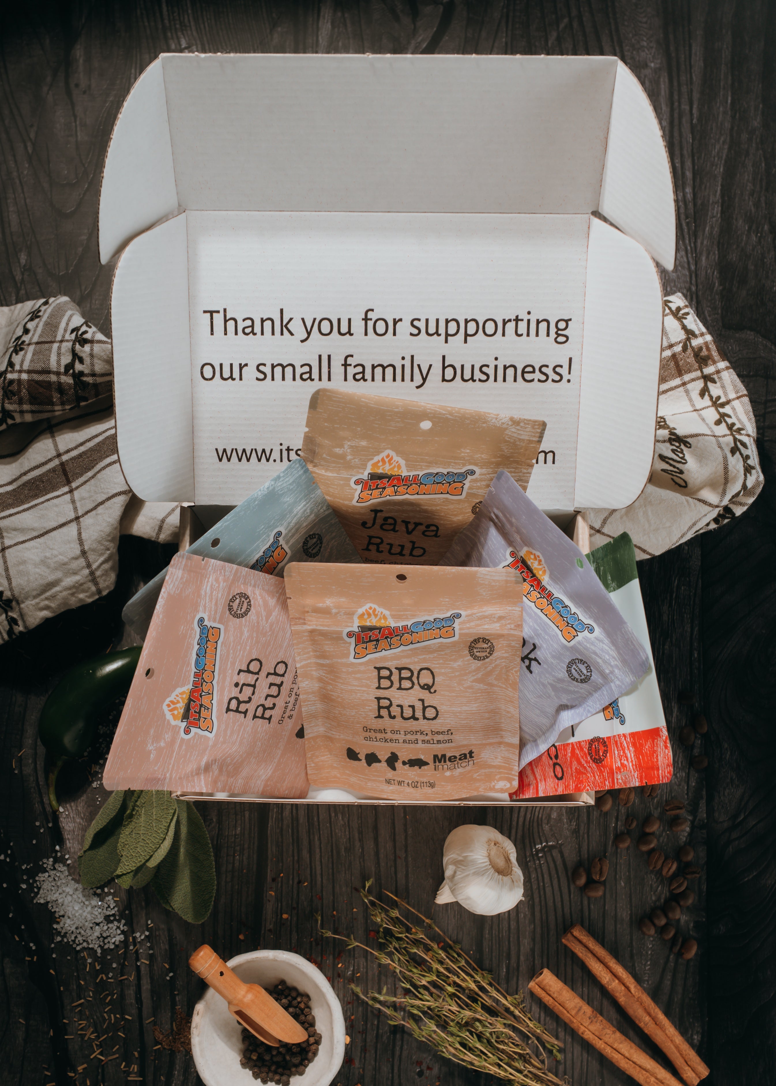 Box of seasoning packets with a thank you message on a wooden surface.